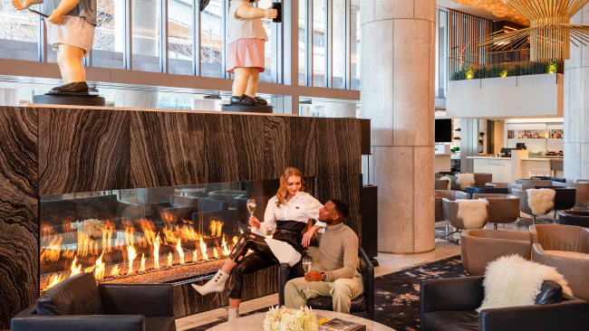 Couple sitting by The Lobby Lounge fireplace
